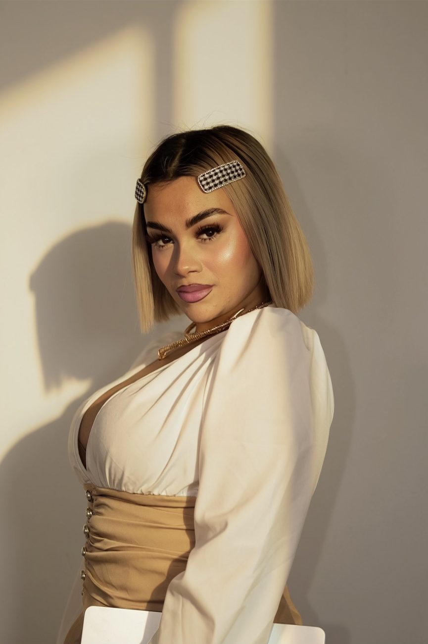 Gem in a cream blouse, lit by golden window light